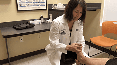 Dr. Davis examines a patient to determine if flat foot reconstruction is necessary.
