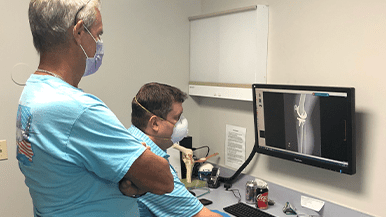 Specialists at Orlando Orthopaedic Center review x-rays for a bilateral total knee replacement.
